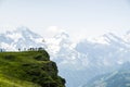 Hikers standing on Swiss mountaintop viewing surrounding mountains