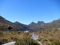 Hikers at a mirror lake at Cradle Mountain, Australia.