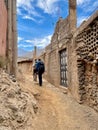 Hikers on Toubkal trek walking through a typical Berber village in the High Atlas Mountains. Imlil valley, Morocco.