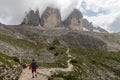 Hikers on a trail in front of Tre Cime di Lavaredo, South Tyrol, the Dolomites, Italy