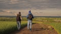 Hikers travel along a country road and admire the beautiful landscape. Travelers with backpacks are walking along the