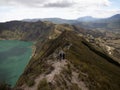 Hikers walking on andean volcano caldera crater lake Quilotoa rim ridge loop in Cotopaxi Ecuador andes South America Royalty Free Stock Photo