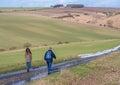 Hikers walking on a country road Royalty Free Stock Photo