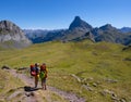 Hikers walking in the Pyrenees National Park with the Midi d`Ossau peak in the background