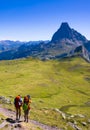 Hikers walking in the Pyrenees National Park with the Midi d`Ossau peak in the background Royalty Free Stock Photo