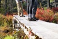 Legs of hikers standing on constructed wooden bridge over wetlands in autumn Royalty Free Stock Photo