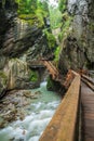 Hiking along a woodend boardwalk in a canyon near Kaprun, Austria Royalty Free Stock Photo