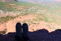Hiking Boots at the edge of a ledge overlooking a vast expanse of Sedona, Arizona