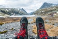 Hiking boots and feet towards icy lake and mountain peaks in Rondane Royalty Free Stock Photo