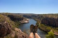Hiking boots and legs above river and canyon. Woman hiking at Katherine gorge. Aerial view. Katherine gorge, Nitmiluk national Royalty Free Stock Photo