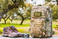 hiking boots, retro camera and camouflage backpack