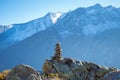 Hiking in Central Switzerland. A cairn marking a footpath, high mountains in the background