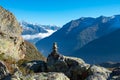 Hiking in Central Switzerland. A cairn marking a footpath, high mountains in the background