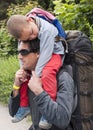 Hiking with child, father carrying sleeping child