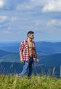 Hiking concept. Power of nature. Man unbuttoned shirt stand top mountain landscape background. Muscular tourist walk