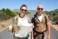 Hiking couple looking at map on the road Royalty Free Stock Photo
