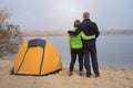 Hiking couple standing near the tent in camp on the river bank, Royalty Free Stock Photo