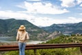 A hiking girl stands by the roadside and looking at the river and mountains. Location: the meanders of Arda river, Bulgaria