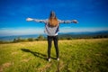 Hiking girl on top of hill with hands up enjoy mountain view