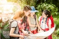 Hiking - hikers looking at map. Couple or friends navigating together smiling happy during camping travel hike outdoors in forest. Royalty Free Stock Photo