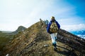 Hiking on Kamchatka: group of hiker with backpack goes in mountain on Volcano Goreliy on a sunny day. Kamchatka Peninsula, Russia