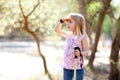 Hiking kid girl searching hand in head in forest