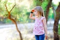 Hiking kid girl searching hand in head in forest