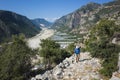 Hiking Lycian way. Man with backpack walking uphill on ancient mountain path with view of beautiful valley of Demre stream Royalty Free Stock Photo