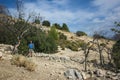 Hiking Lycian way. Man is standing on dry stony highland under dead tree on stretch between Kalkan and Kas of Lycian way