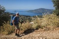 Hiking Lycian way. Man tourist is standing on path over Mediterranean sea coast on Lycian Way trail above Kalkan, Trekking