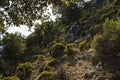 Hiking Lycian way. Man is trekking on steep slope stony path, on mountain on Mediterranean coast, evening warm light