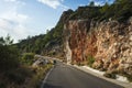 Hiking on Lycian way trail route from Finike to Karaoz. Man is trekking on mountain road with high dramatic cliff