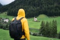Hiking man with backpack enjoy the view of St. Johann church in Val di Funes valley, Dolomites, Italy, Europe Royalty Free Stock Photo