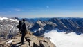 Hiking man with big backpack standing on rock with scenic view on Hoher Sonnblick glacier, High Tauern mountains in Carinthia,