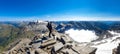 Hiking man with big backpack standing on rock with scenic view on Hoher Sonnblick glacier, High Tauern mountains in Carinthia,