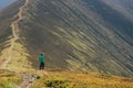 Hiking man, climber or trail runner in mountains, inspirational landscape. Motivated hiker looking at mountain view. Royalty Free Stock Photo