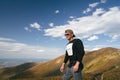 Hiking man, climber or trail runner in mountains, inspirational landscape. Motivated hiker looking at mountain view. Royalty Free Stock Photo