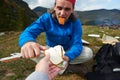 Hiking man slice tasty cheese on picnic