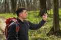 Hiking man take selfie during his walk through the forest