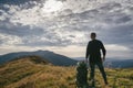 Hiking man or trail runner in mountains, inspirational landscape. Motivated hiker with backpack looking at mountain view Royalty Free Stock Photo