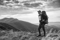 Hiking man or trail runner in mountains, inspirational landscape. Motivated hiker with backpack looking at mountain view Royalty Free Stock Photo