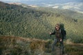 Hiking man or trail runner in mountains, inspirational landscape. Motivated hiker with backpack looking at mountain view Royalty Free Stock Photo