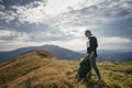 Hiking man or trail runner in mountains, inspirational landscape. Motivated hiker with backpack looking at mountain view Royalty Free Stock Photo