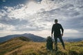 Hiking man or trail runner in mountains, inspirational landscape. Motivated hiker with backpack looking at mountain view Royalty Free Stock Photo