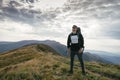 Hiking man or trail runner in mountains, inspirational landscape. Motivated hiker with backpack looking at mountain view Royalty Free Stock Photo