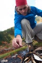 Hiking man try to light fire Royalty Free Stock Photo