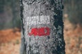 Hiking marks on a tree trunk. Red and white signal along hiking trail. Signal trail in the mountains. Hiking through the forest.