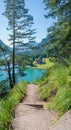 Hiking path along the lakeside of achensee, view to gaisalm hut, vertical format