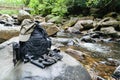 Hiking sandals, backpack, cap and camera on a big rock Royalty Free Stock Photo