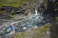 Hiking in Swedish Lapland. Man with backpack looking waterfall, trekking alone in Vistasvagge valley in northern Sweden